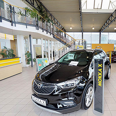 Ausstellungsraum im Autohaus H. Freitag mit Fahrzeugen und Galerie